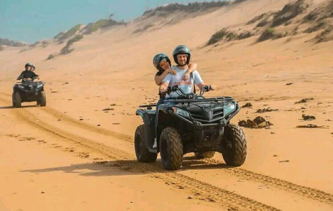 Quad biking through the Timlalalin Sand Dunes near Agadir, Morocco, with stunning Atlantic Ocean views and golden desert landscapes.