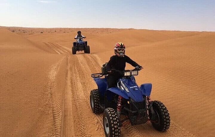 Riders enjoying a quad biking adventure through the Timlalalin Sand Dunes near Agadir, Morocco.