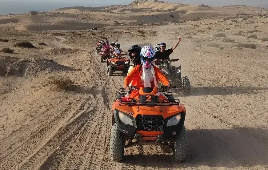 Adventure quad biking across the golden Timlalalin Sand Dunes near Agadir with panoramic views of the Atlantic coastline.