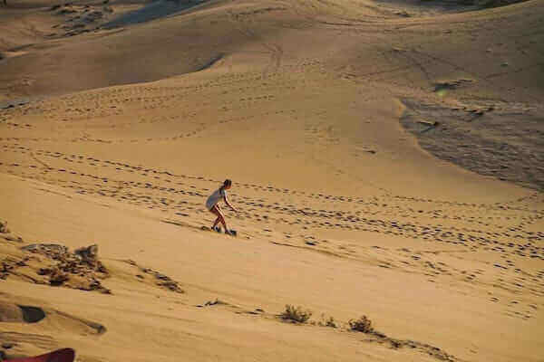 Panoramic view of the Timlalin Dunes with sandboarding activity near Agadir.